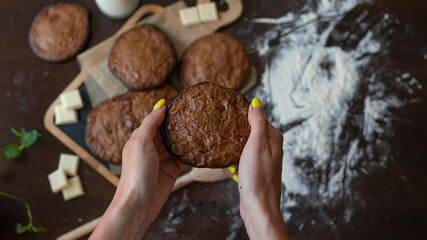 homemade brownie chocolate cookies in the hands of a woman