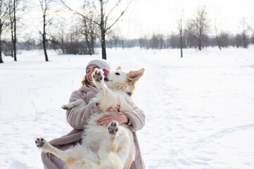 Young beautiful woman and her golden retriever dog having fun in winter.