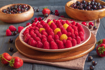 Fresh juicy berries are laid out neatly on plates
