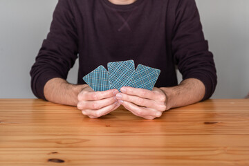 Unrecognizable person holding three playing cards