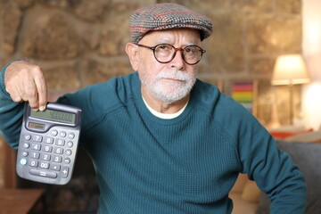 Senior man holding a calculator