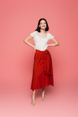 Stylish woman with vitiligo looking at camera on pink background
