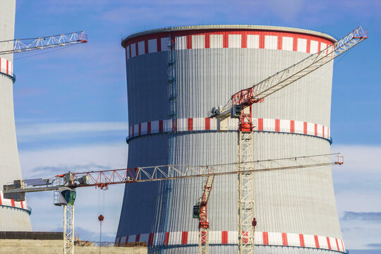 Cooling tower of environmentally friendly nuclear power plant under construction and lifting tower crane