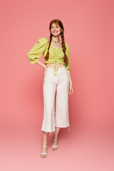 Cheerful woman with freckles standing on pink background