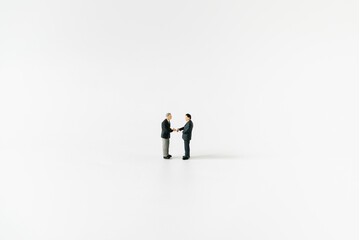 Miniature businessman handshake partner client customers with success dealing business using as...