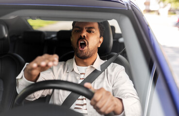 transport, vehicle and people concept - angry indian man or driver driving car