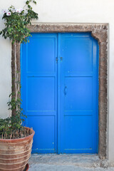 Traditional blue door, typical cycladic architecture of whitewashed houses with colored doors and windows, here as seen in Pyrgos, a traditional village in famous Santorini island, Greece, Europe