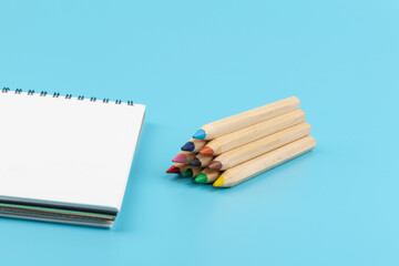 Obraz premium Blank paper and a colorful pencil on a blue background