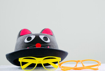 felt hat black with a cat's face and colored eyeglass frames