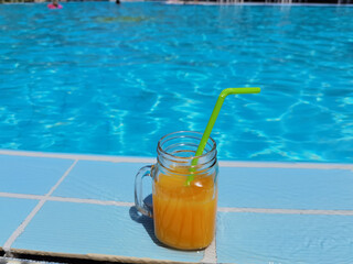 orange juice by swimming pool in summer holidays