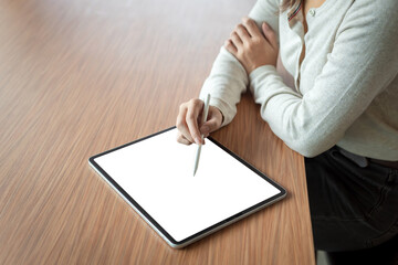Close-up of a businesswoman hand holding a stylus using a tablet blank white screen at the office. Mock up.