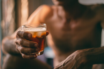 Liquor glass in the hands of a middle-aged man, concept of poor man alcohol addiction and depression because of life problems, Strain during the economy has stalled due to covid pandemic, Cinema tone.