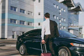 Bottom back rear view young traveler businessman young man wearing black dinner suit walk go...