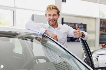 Fun man customer buyer businessman client in white shirt show thumb up get out car chooses auto want buy new automobile in showroom vehicle salon dealership store motor show indoor Car sales concept.