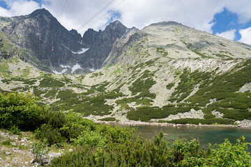 Naklejka na ściany i meble Scenic view of Skalnate Pleso (Rocky Tarn) and cable car heading to Lomnicky Stit peak in High Tatra mountains, Slovakia. Beautiful clean nature in Central Europe, cloudy day in summer