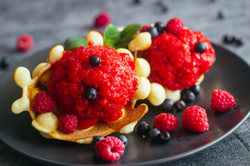 Delicious hong kong waffles. Waffles with strawberry ice cream and berries. Waffles on the table 