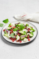 Healthy summer raw pomegranate cucumber salad, red onion mint vinegar gressing. Space for text.