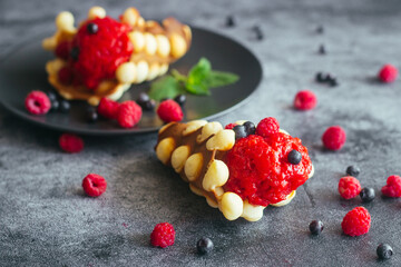 Delicious hong kong waffles. Waffles with strawberry ice cream and berries. Waffles on the table 