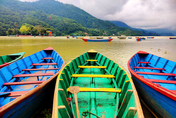 Boats on the lakeside. Phewa Lake in Pokhara, Nepal.
fishing boat in calm lake water, an old wooden...