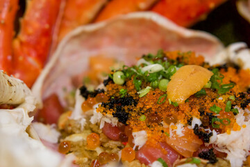 Taraba fried rice in the crab shell consists of tobiko, Ikura roe, salmon and tuna sashimi. Japanese seafood.
