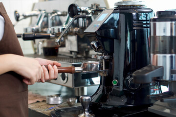 Fototapeta na wymiar Barista making fresh espresso coffee. Espresso Machine Portafilters. Closeup
