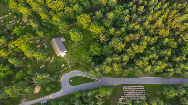 Aerial view to the historic small chapel with the thatched roof and wooden top of the bell tower on the coastal cemetery in Kassari, Hiiumaa island, Estonia