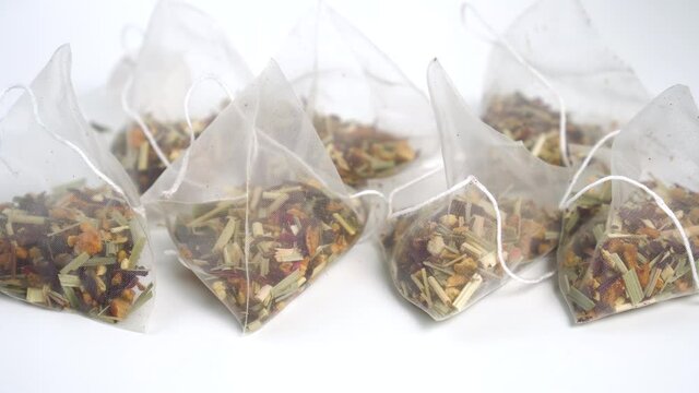 A group of micro plastic tea bags of floral fruit herbal tea. Close-up. Dolly Shot