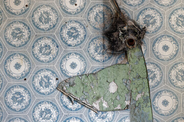 Old soviet union kitchen wall, cracked green paint, dirty blue wallpaper and exploded gas pipe