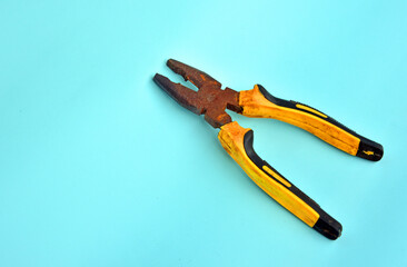 Rusty Tong in yellow black color isolated on light blue background