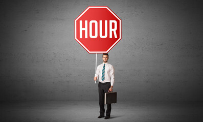 Obraz premium Young business person holding road sign