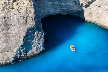 Photo sur Plexiglas Plage de Navagio, Zakynthos, Grèce A boat in the lagoon near Navagio Beach, Zakynthos Island, Greece. View of the sea bay and a lone boat from a drone. Blue sea water. Vacation and travel. Summer landscape from the air.