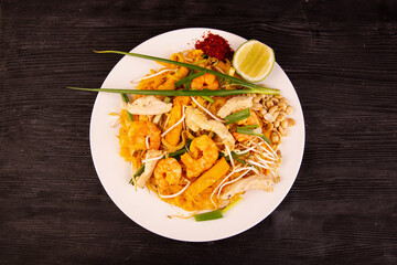 pad tai, rice noodles with pieces of chicken, tofu, bean sprouts, greens