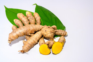 Sliced turmeric leaves and turmeric root isolated on white background close-up