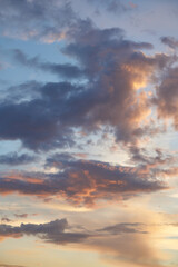 Beautiful evening blue sky at sunset with flaming bright light clouds. A warm summer evening at sunset. Bright sunset.