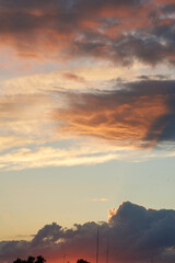 Beautiful evening blue sky at sunset with flaming bright light clouds. A warm summer evening at sunset. Bright sunset.