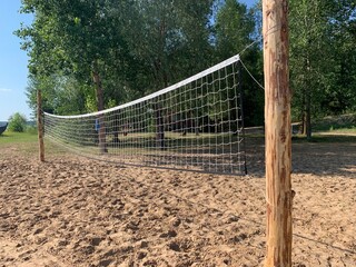 sport net on the beach; A beach volleyball net on a sunny day, on an empty beach forest
