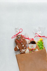 Colourful Christmas gingerbread cookies with sugar icing over a white snowy background