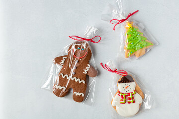 Colourful Christmas gingerbread cookies with sugar icing over a white snowy background