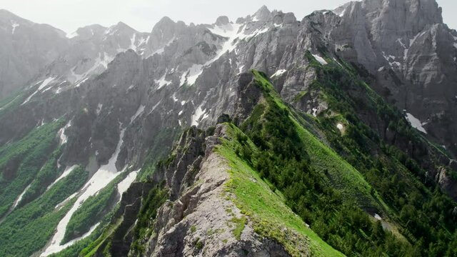 Flying over the ridge at Valbona pass in Albanian Alps. Rocky mountain range between villages Thethi and Valbona, Albania. Camera moves along the edge of the cliff, Prokletije mountains