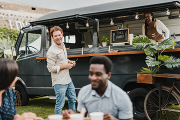 Man talking with friends near food truck with seller