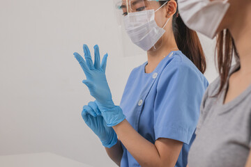 Covid-19,coronavirus hand of young woman doctor or nurse putting on blue nitrile surgical gloves,...
