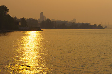 Fototapeta premium Forest fires smoke shrouded lake coast of city in summer day
