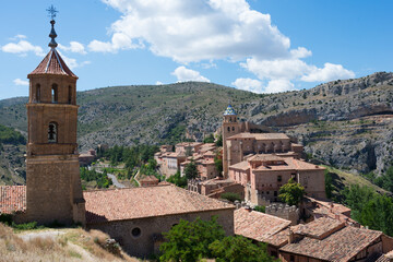 Fototapeta na wymiar Beautiful aerial view of Albarracin, an ancient village of Teruel, seen from its fortress. Traditional buildings of stone, church, and mountains around. Spain, Europe
