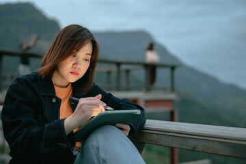 asian woman use tablet for stock and cryptocurrency trading from outdoor of coffee shop