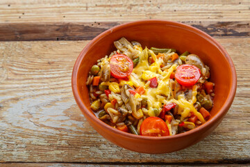 Risotto with mushrooms and cheese in a clay plate on a wooden background.