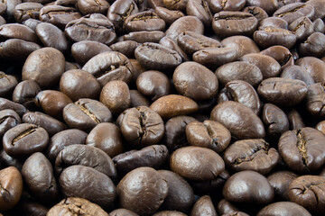 Roasted coffee beans, coffee beans text background in full focus.