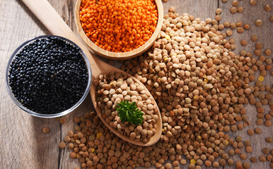 Composition with three sorts of lentils on wooden table