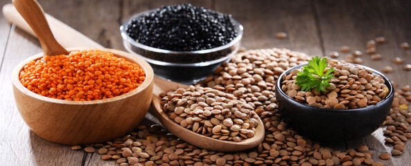 Composition with three sorts of lentils on wooden table