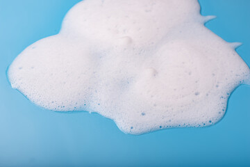 Soap foam on a blue background. The concept of hygiene, cleanliness.