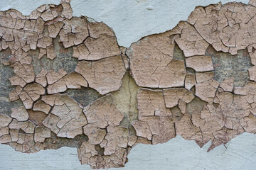 An old wall in a dilapidated house. Peeling plaster, background and texture